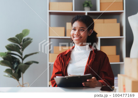 American African entrepreneur smile and working to check online order. Successful SME entrepreneur concept 100477169