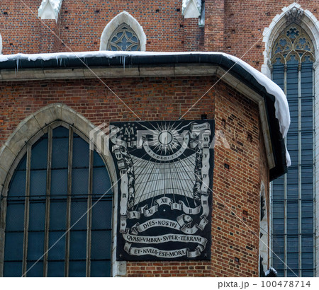 Wall sundial on the brick wall of the ancient St. Mary's Cathedral in Krakow Wall sundial on the brick wall of the ancient St. Mary's Cathedral in Krakow 100478714
