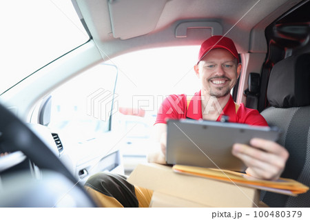 Courier is engaged in logistics of delivery and holds tablet 100480379
