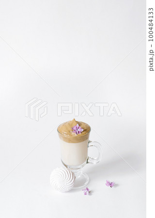 Dalgon's trending drink is coffee. Coffee mug, lilac and marshmallow on a white background. Copying space 100484133