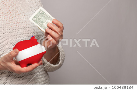 Flag of Austria on money bank in Austrian woman hands. Flag of Austria on money bank in Austrian woman hands. 100489134