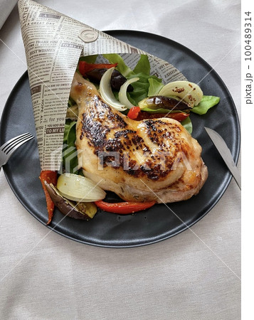 ブーケ風に盛り付けをしたチキンとグリル野菜にナイフとフォークを添えて ブーケ風に盛り付けをしたチキンとグリル野菜にナイフとフォークを添えて 100489314