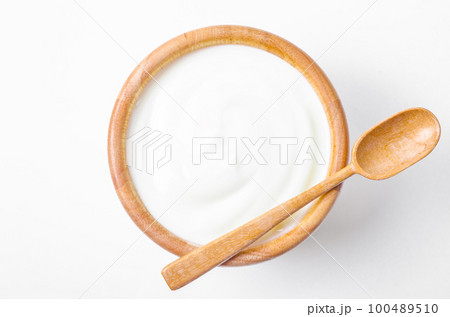 The Fresh greek yogurt in wooden bowl with wooden spoon on white background. Healthy breakfast. 100489510
