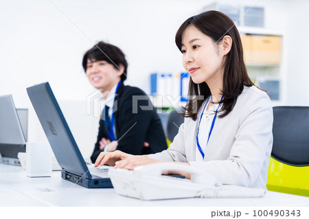 笑顔でデスクワークをする女性 笑顔でデスクワークをする女性 100490343