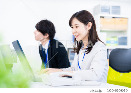 笑顔でデスクワークをする女性 笑顔でデスクワークをする女性 100490349