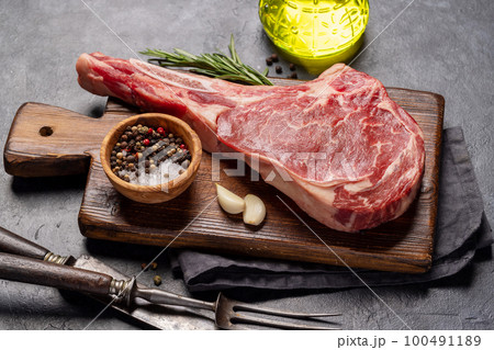 Raw Tomahawk beef steak and spices 100491189