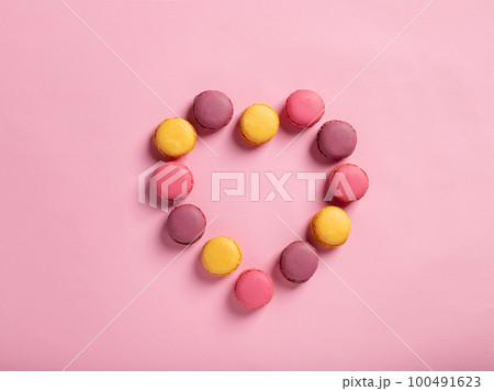 Heart shape made of delicious macarons on a pink background. Heart shape made of delicious macarons on a pink background. 100491623