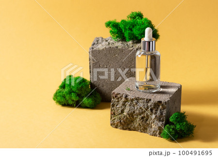 glass bottle with cosmetic serum on creative brick podium 100491695