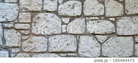Sturdy yellow and beige cut stone wall, seamless lined up Sturdy yellow and beige cut stone wall, seamless lined up 100494473