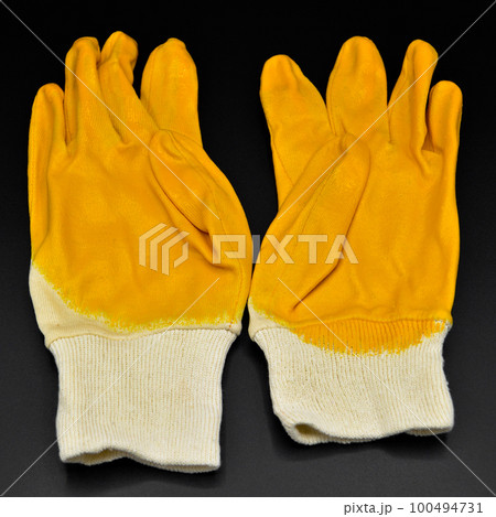 New and protective yellow work gloves isolated on black background 100494731