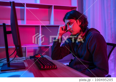 Handsome boy playing E-Sport game or streamer, Defeat or failure, Mistakes of managing a team in the game lead to defeat,  Live show play games, Blue and red lights 100495205