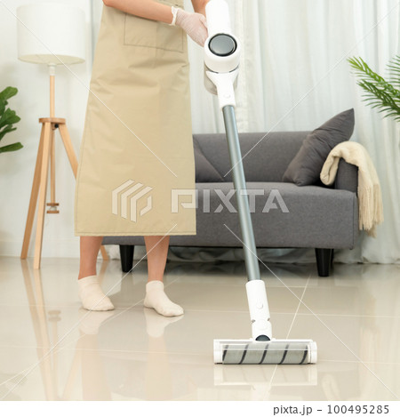 Housekeeper is use mop with vacuum cleaner to housekeeping with vacuuming and wiping dirty laminate 100495285