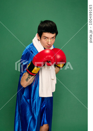 Portrait of boxer in uniform posing over green background. Concept of sport, competition, training, energy 100499165