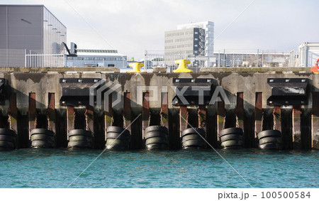 Mooring wall with rubber bumpers and yellow bollards. Close up photo Mooring wall with rubber bumpers and yellow bollards. Close up photo 100500584