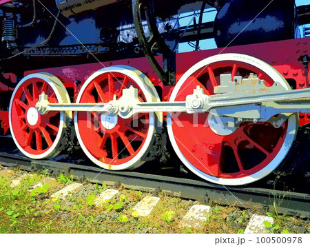 Retro vintage wheels of a locomotive or train close up. Red large heavy metal wheels with piston guiding mechanisms. Locomotive of the 19th - 20th centuries with a steam engine. Bright vivid photo 100500978