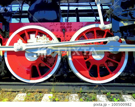 Retro vintage wheels of a locomotive or train close up. Red large heavy metal wheels with piston guiding mechanisms. Locomotive of the 19th - 20th centuries with a steam engine. Bright vivid photo 100500982