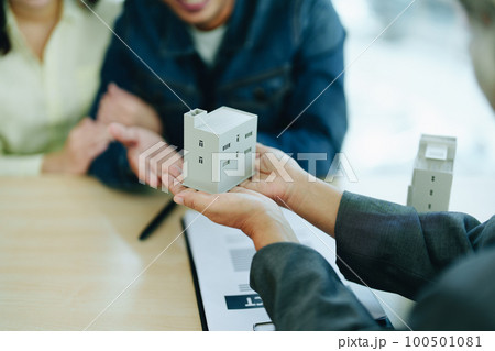 Guarantee Insurance Sign a contract, couple a smiling couple is signing a contract to invest in real estate with the Mortgage officer with the bank. 100501081