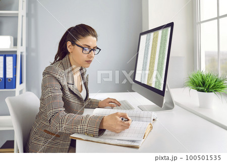 Business accountant checking financial records and working with spreadsheets on computer 100501535