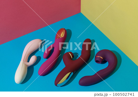 Many dildo vibrators for satisfaction on colored background. Sex toy for adult. Sex shop concept 100502741