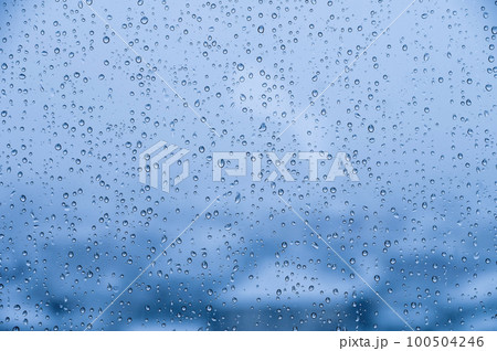 Natural water drops on glass. macro raindrops on the blue window of a car or house window 100504246