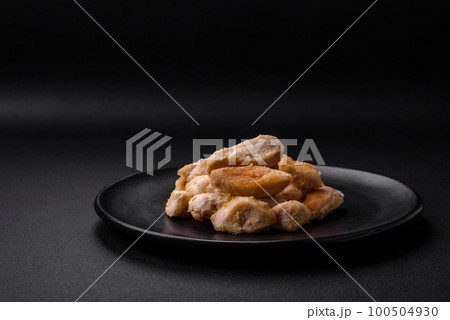 Delicious chicken slices baked with spices and herbs on a round ceramic plate 100504930