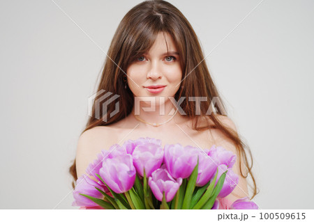 portrait of a woman topless with a bouquet of tulips on a white background. portrait of a woman topless with a bouquet of tulips on a white background. 100509615