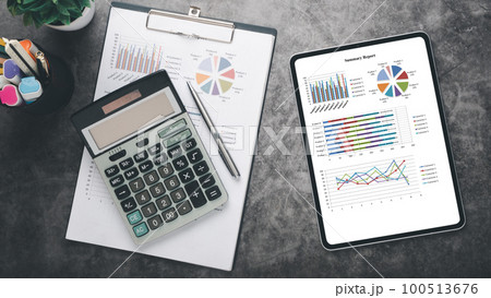 Tablet with charts and reports on office desk workplace. Top view flat lay. Tablet with charts and reports on office desk workplace. Top view flat lay. 100513676