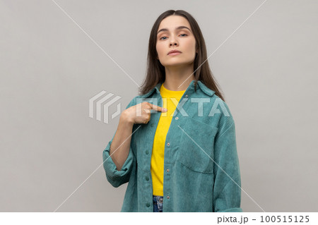 Confident egoistic woman pointing on herself with arrogance and satisfaction, proud of herself, bragging with achievements, wearing casual style jacket. Indoor studio shot isolated on gray background. 100515125