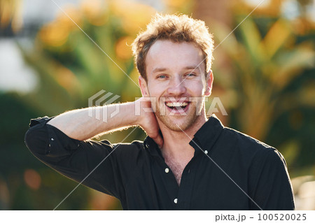 Young man is outdoors at sunny daytime. Concept of vacation 100520025