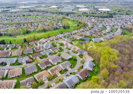 View of small American town residential complex district with houses and roads on an aerial view with spring trees View of small American town residential complex district with houses and roads on an aerial view with spring trees 100520536