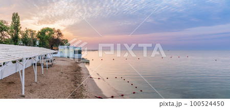 Tranquil Beach Sunrise. Closeup sea sand beach. Beautiful panoramic landscape, colorful golden sunrise over calm sea with waves 100524450