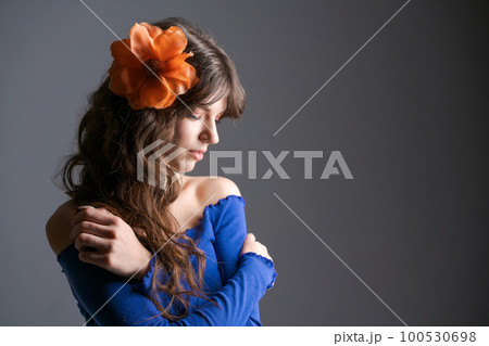 Portrait young woman with an artificial flower in her hair. Natural beauty 100530698