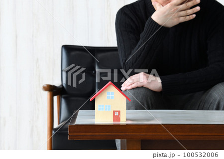 家づくり失敗イメージ―住宅の模型と悩む男性 100532006