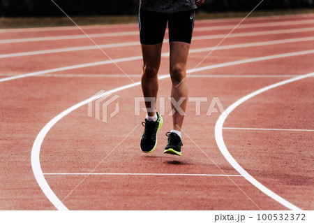 陸上競技のトラックを走るランナー 100532372