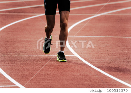 陸上競技のトラックを走るランナー 100532379