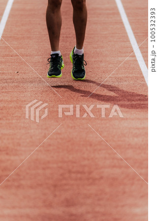 陸上競技のトラックの直線を走る男性ランナー 100532393