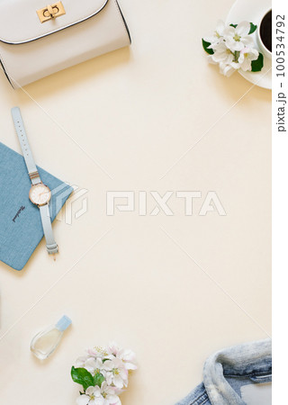 The workplace of a female blogger. A denim jacket, sneakers, a cup of coffee, a camera, a wristwatch and a notebook with a pen on the background with a copy location The workplace of a female blogger. A denim jacket, sneakers, a cup of coffee, a camera, a wristwatch and a notebook with a pen on the background with a copy location 100534792