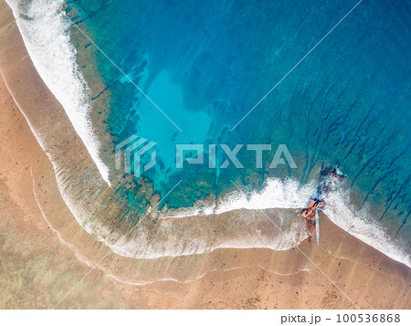 Aerial view of Sea waves reaching tropical beach landscape Aerial view of Sea waves reaching tropical beach landscape 100536868