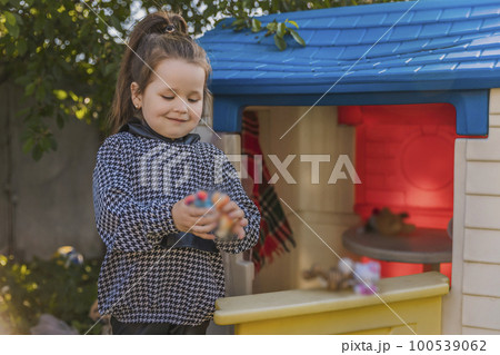 girl playing in her little house 100539062