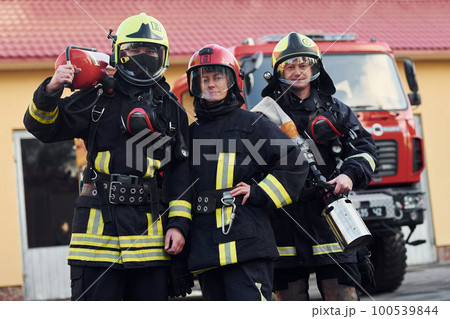 Group of firefighters in protective uniform that outdoors near truck 100539844