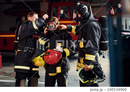 Group of firefighters in protective uniform that is on station Group of firefighters in protective uniform that is on station 100539900
