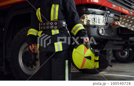 Close up view. Female firefighter in protective uniform standing near truck Close up view. Female firefighter in protective uniform standing near truck 100540728