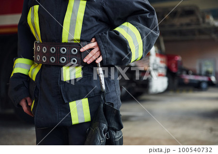 Close up view. Female firefighter in protective uniform standing near truck Close up view. Female firefighter in protective uniform standing near truck 100540732