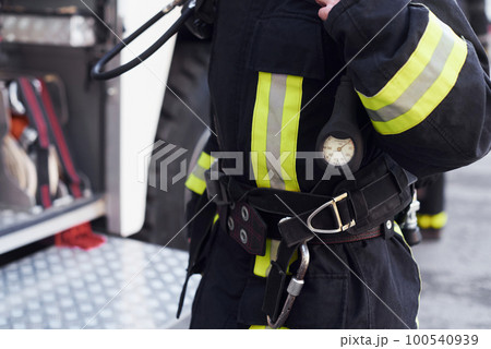 Female firefighter in protective uniform standing near truck Female firefighter in protective uniform standing near truck 100540939