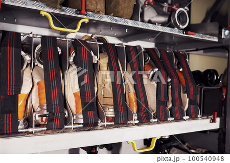 Firefighter's equipment in the car. Hoses hanging inside of vehicle 100540948