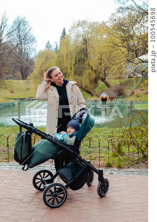 Happy boy sitting in a stroller with mom Happy boy sitting in a stroller with mom 100545698