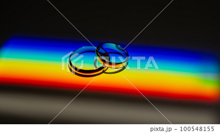 Rainbow beam on wedding rings. lgbt flag.  100548155
