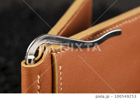 Part of a brown leather wallet or case with stitching. Part of a brown leather wallet or case with stitching. 100549253