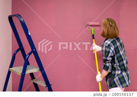 Redecorating. Painting walls with paint-roller 100550137