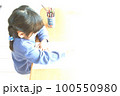 机にむかって何かの作業をしている女の子 100550980